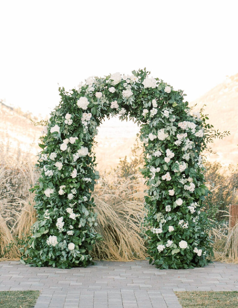 White Floral and greenery ceremony arch at The Manor House in Littleton, Colorado by Amanda Berube